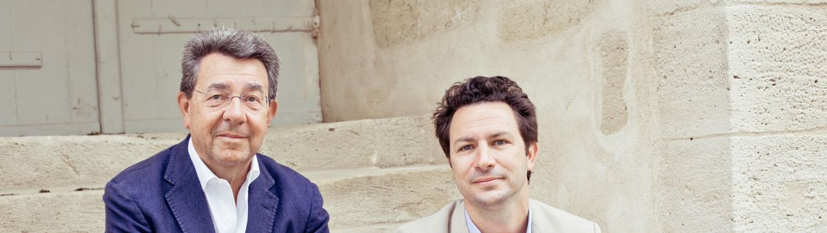 Zwei Männer sitzen auf Steintreppe von Chateau Clos Fourtet