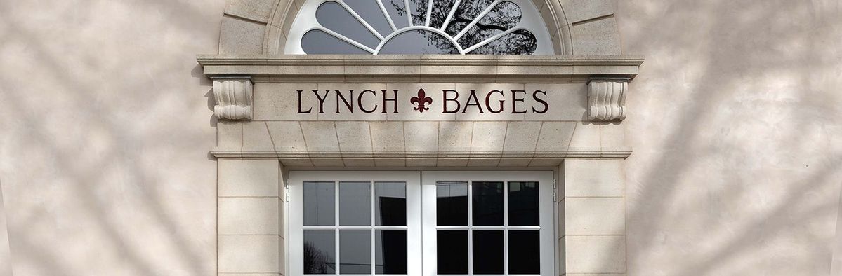 Weiße Eingangstüren In einem Steingebäude zum Chateau Lynch Bages