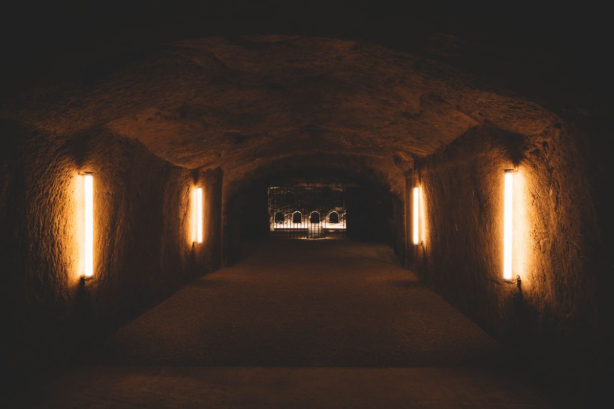 Dunkler Steinkeller von Chateau Clos Rougeard mit LED Lichter an der Wand