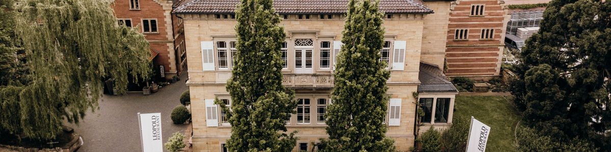 Gebäude von Weingut von Winning mit zwei Bäumen im Vordergrund