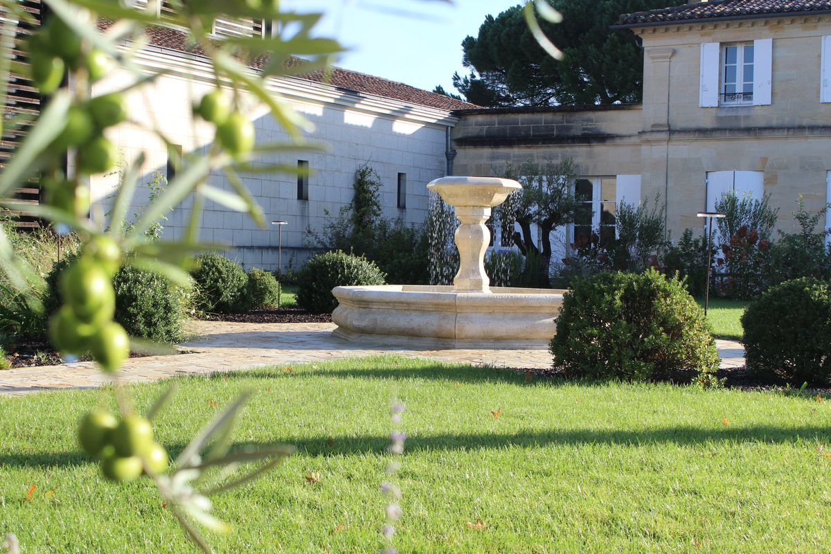 Vorgarten von Chateau La Fleur de Bouard mit Springbrunnen und grüner Wiese