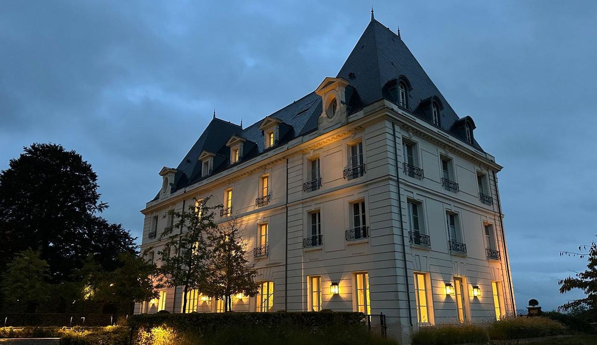 Weißes Gebäude von Moet et Chandon mit dunklem Dach im Abendlicht