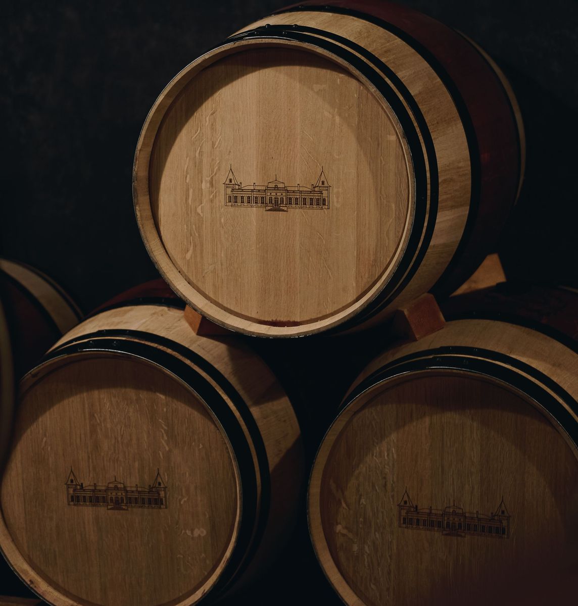 Drei Holzweinfässer mit Logo von Chateau Tronquoy Lalande eingebrannt
