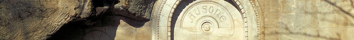 Gebogener Schriftzug Ausone über einem Steinbogen über einer Tür an der Steinmauer eines Gebäudes von Château Ausone.