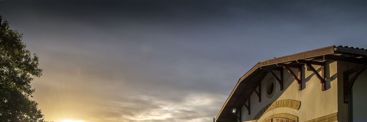 Sonnenaufgang vor weißem Gebäude von Chateau Duhart Milon Rothschild