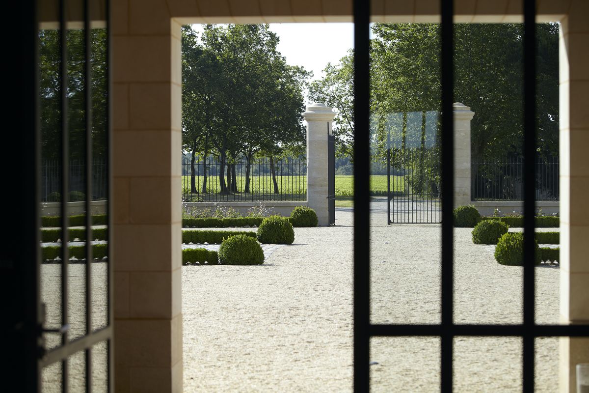 Sicht aus dem Gebäude von einer Glastüre mit Garten von Chateau de Fieuzal im Hintergrund