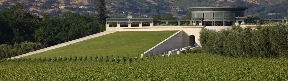 Außenaufnahme vom Weingut Opus One mit den Weinbergen im Vordergrund.