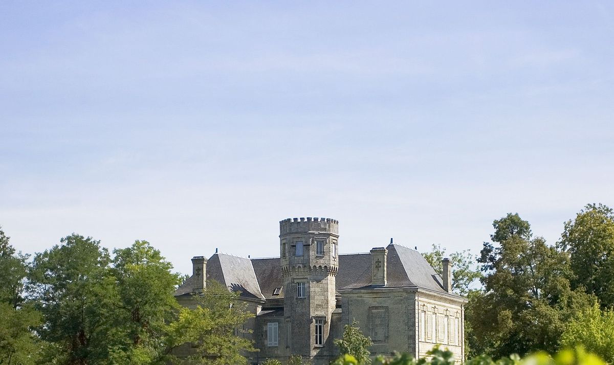 Burggebäude von Chateau la gurgue unter blauem Himmel und von Bäumen umgeben