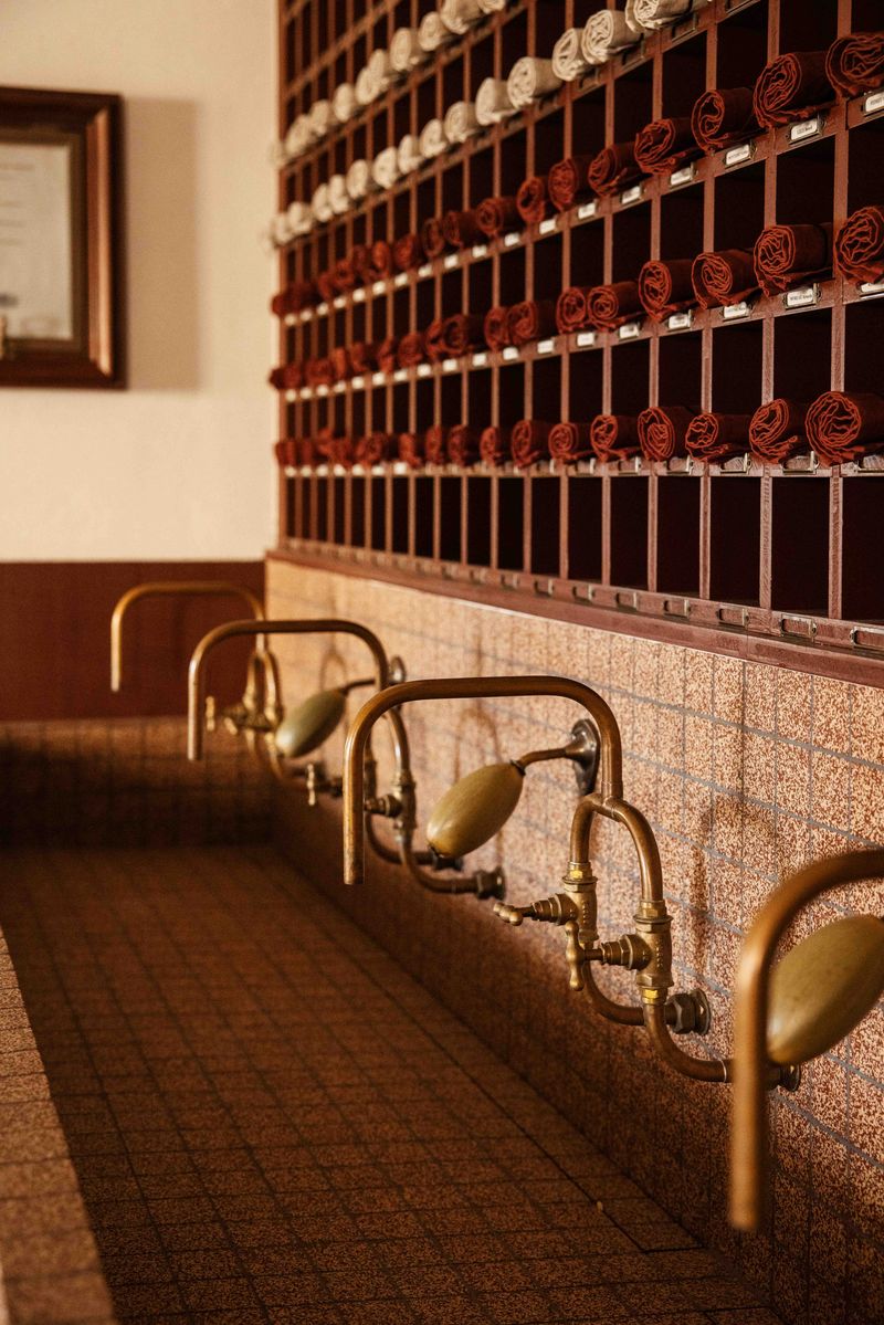 Wasserhähne aus Kupfer mit Steinspühlbecken und Holzregal für Handtücher von Chateau Palmer