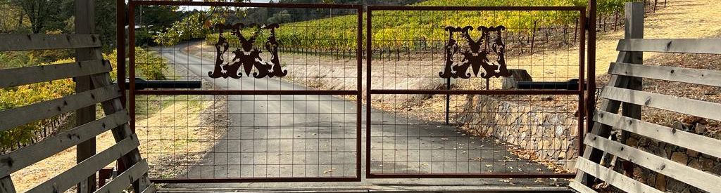 Eingangstor aus Metall mit Logo, welches zum Weingut Mayacamas führt.