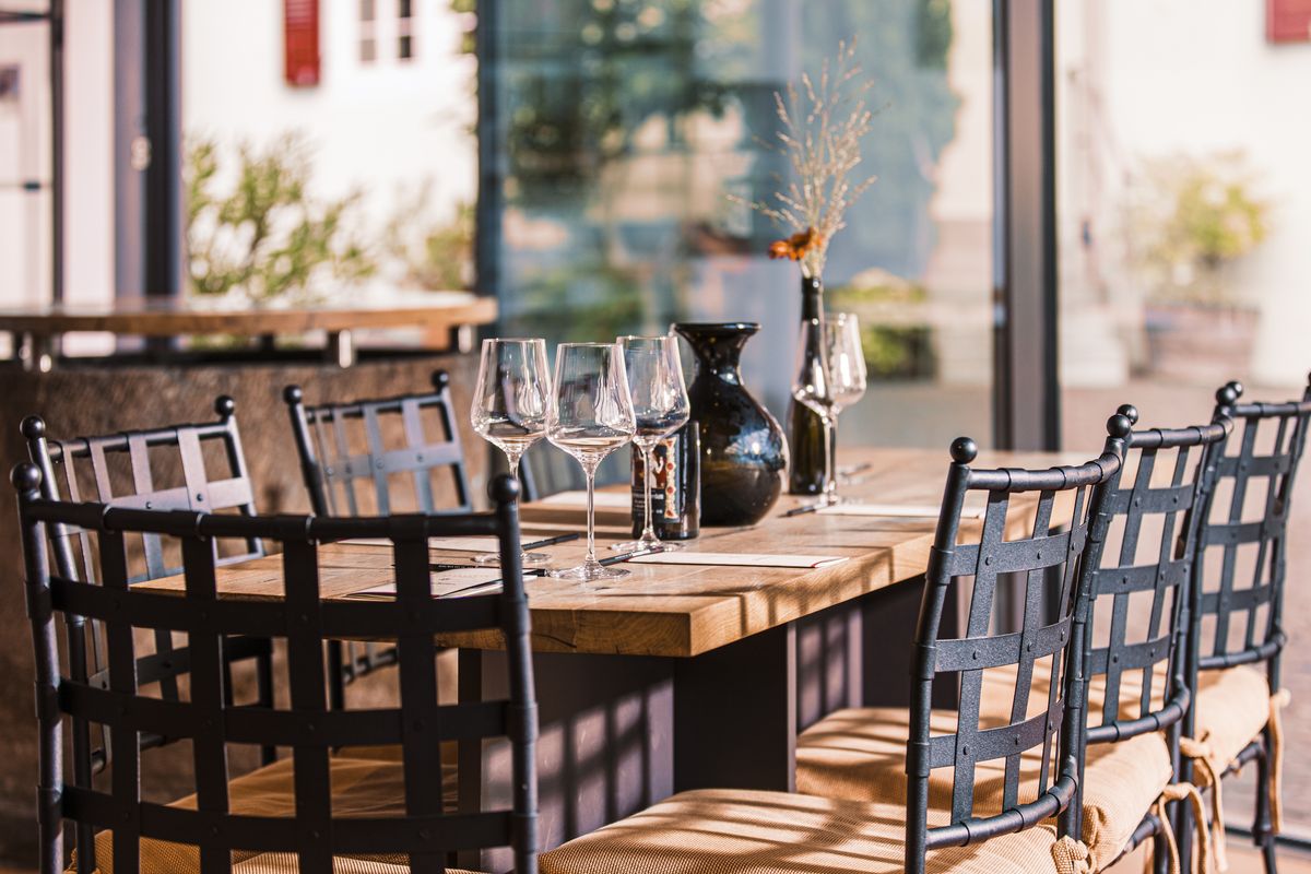 Gedeckter Tisch mit Stühlen und Weingläsern auf dem Tisch in der Vinothek von Bassermann Jordan