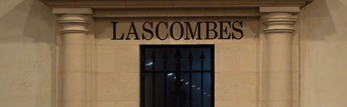 Schriftzug Lascombes über einem Steintor in einer Wand