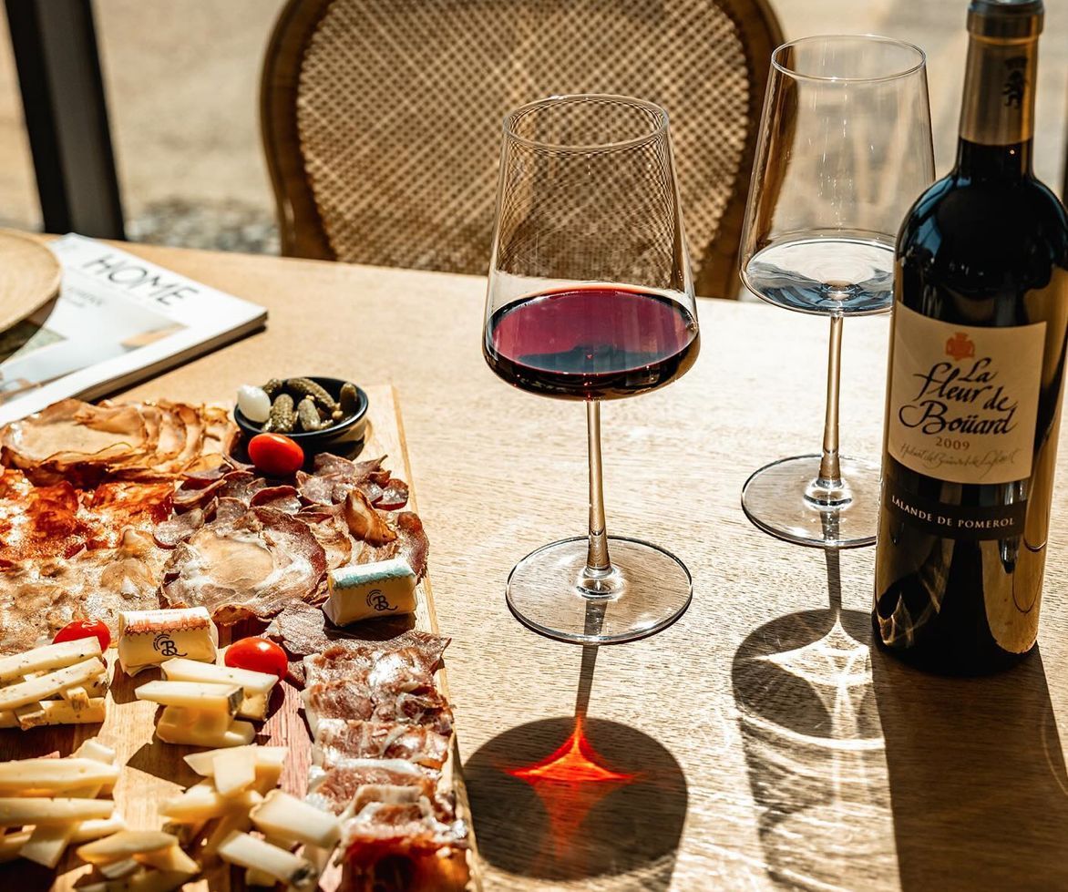 Tisch mit charcurteri Board und Weingläsern mit Rotwein von Chateau La Fleur de Bouard