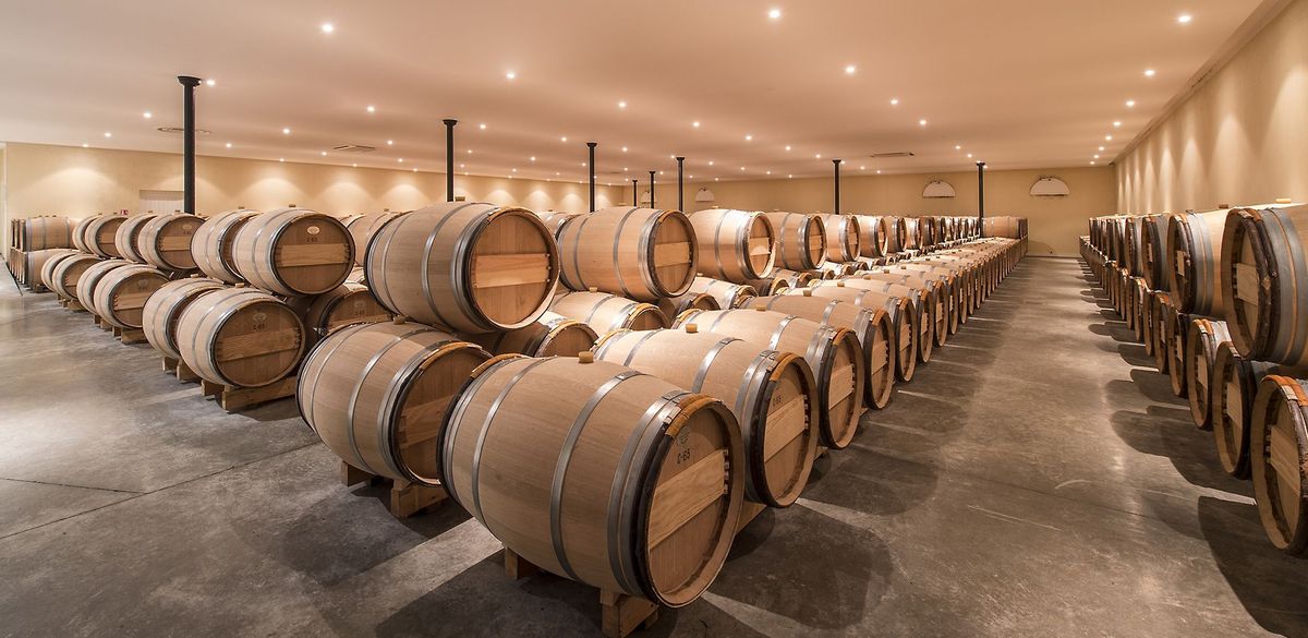 Weinkeller mit aufeinandergestapelten Holzweinfässern von Chateau Rieussec