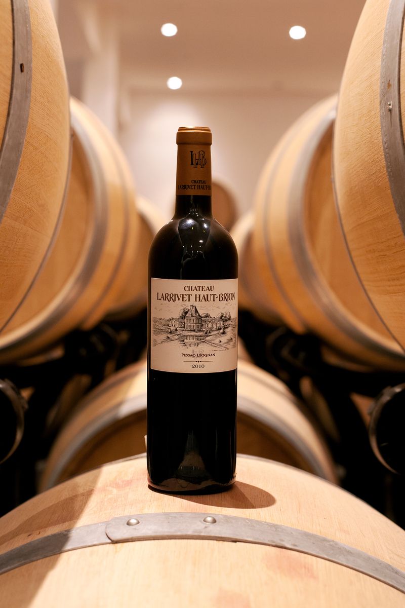 Weinflasche von Chateau Larrivet Haut Brion steht auf Holzweinfass